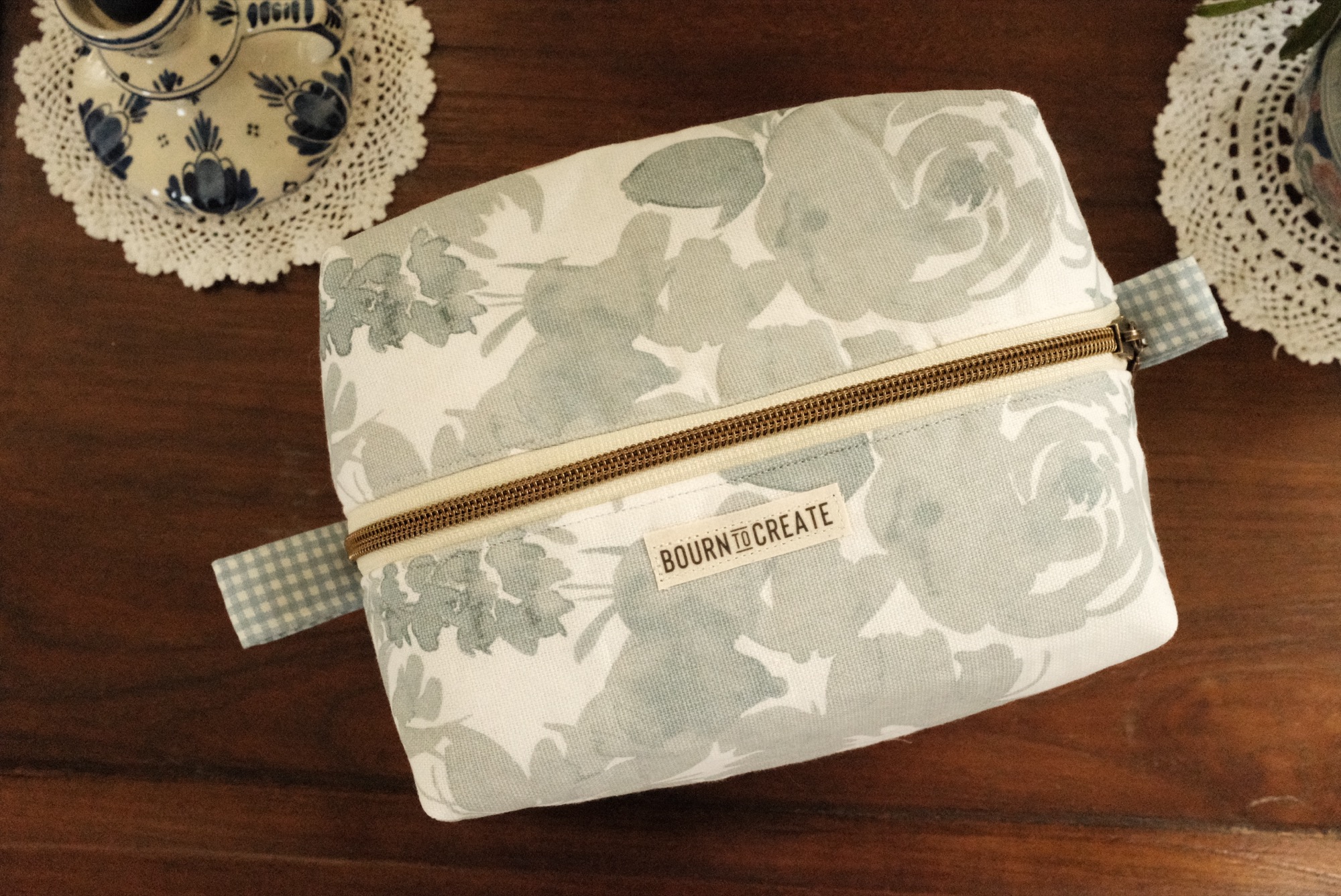Boxy zip makeup bag in a soft sage watercolor floral with a gingham lining