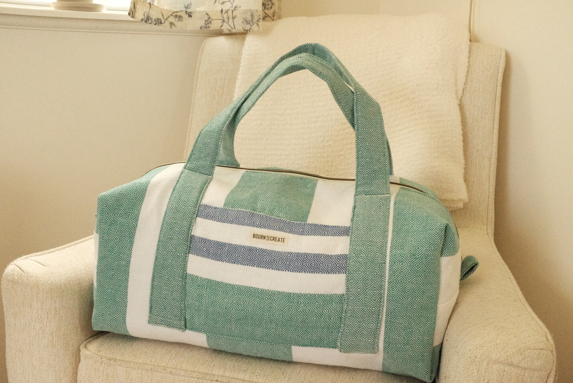 The seaside duffle — a seafoam-and-white striped bag, handmade in Biloxi
