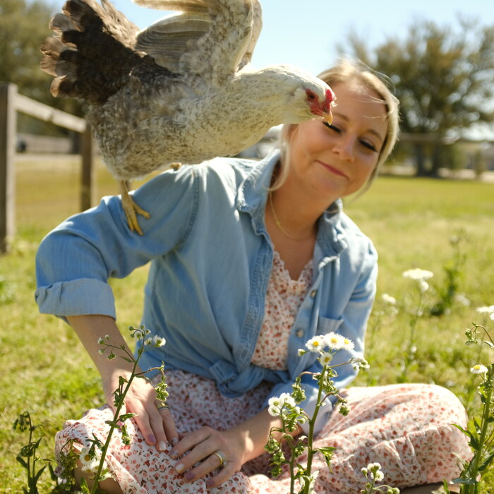 Sarah out in the yard with a chicken